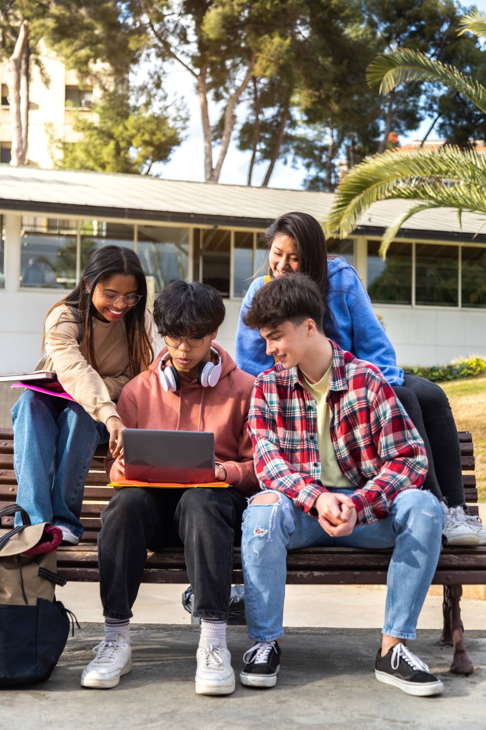 Group of multiracial college student doing university research homework and studying together on campus. Vertical