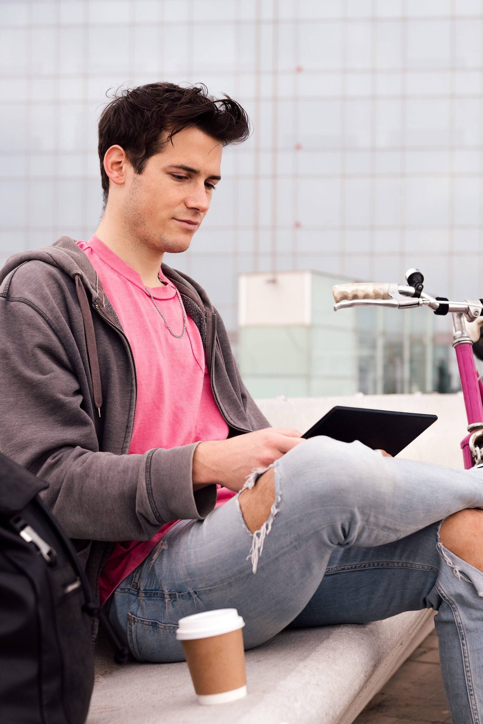 vertical photo of a student using tablet outdoors